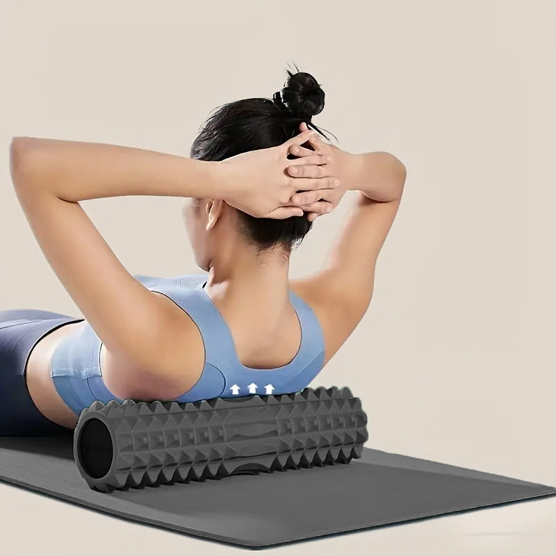 Femme utilisant un rouleau de massage noir pour détendre les muscles du dos après une séance de yoga ou d’exercices